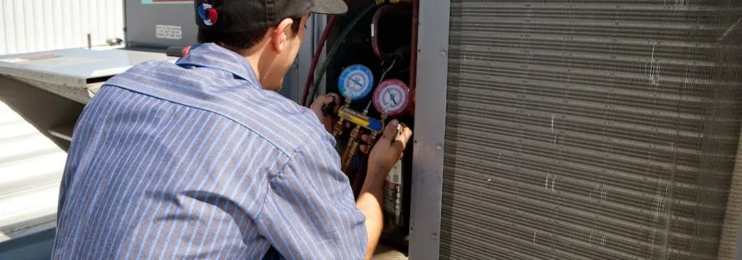 HVAC technician servicing a condenser unit in Fanwood